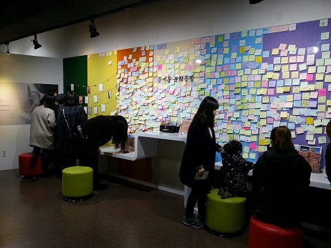 손글씨로 엽서 쓰는 관람객.jpg